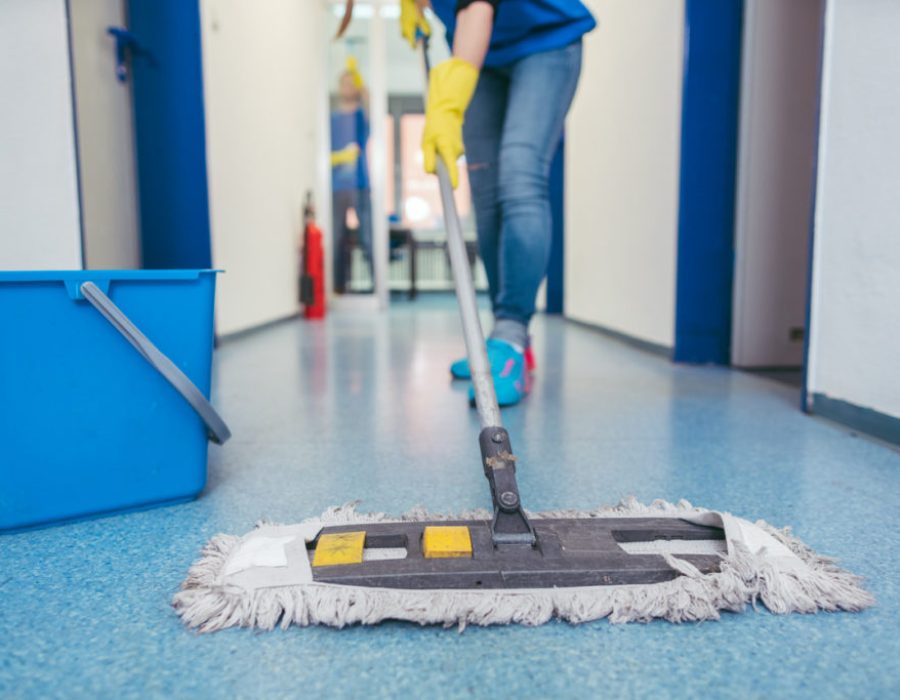 Close-up of cleaners moping the floor of a hall